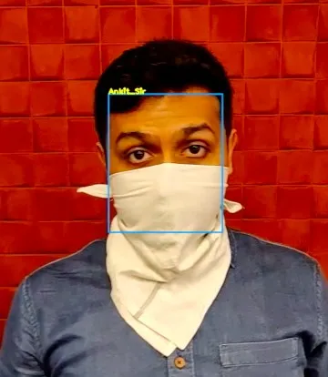 The same man wearing a cloth mask covering his nose and mouth, still inside a detection box carrying the same name.